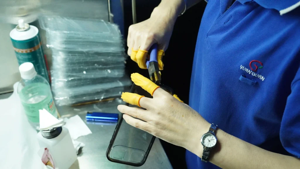 Worker trimming plastic runner from injection molded part manually